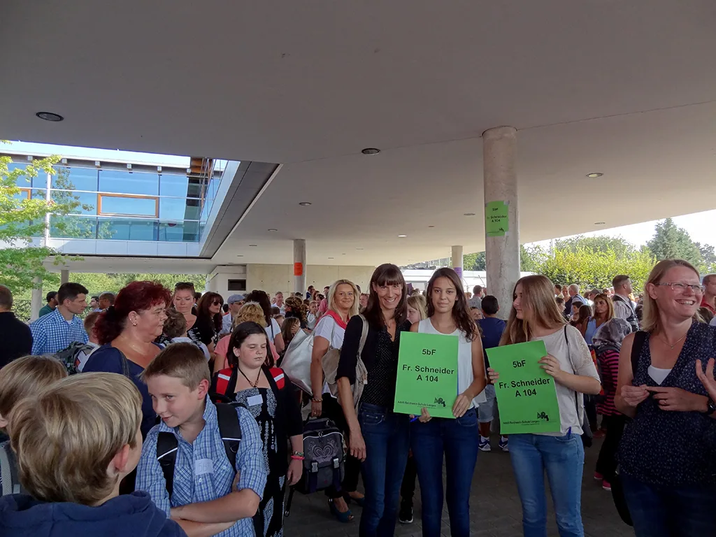 Personen mit grünen Klassenschildern im Gedränge.